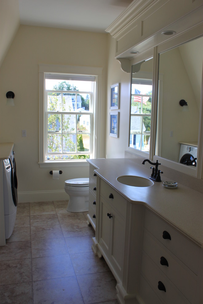 Inspiration for a large traditional 3/4 bathroom in Portland Maine with shaker cabinets, white cabinets, beige tile, ceramic tile, beige walls, ceramic floors, an undermount sink, laminate benchtops and a laundry.