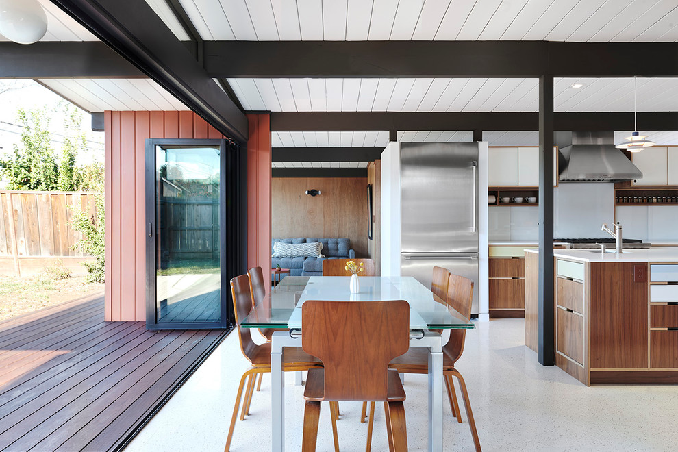 This is an example of a midcentury open plan dining in San Francisco with vinyl floors, no fireplace and white floor.