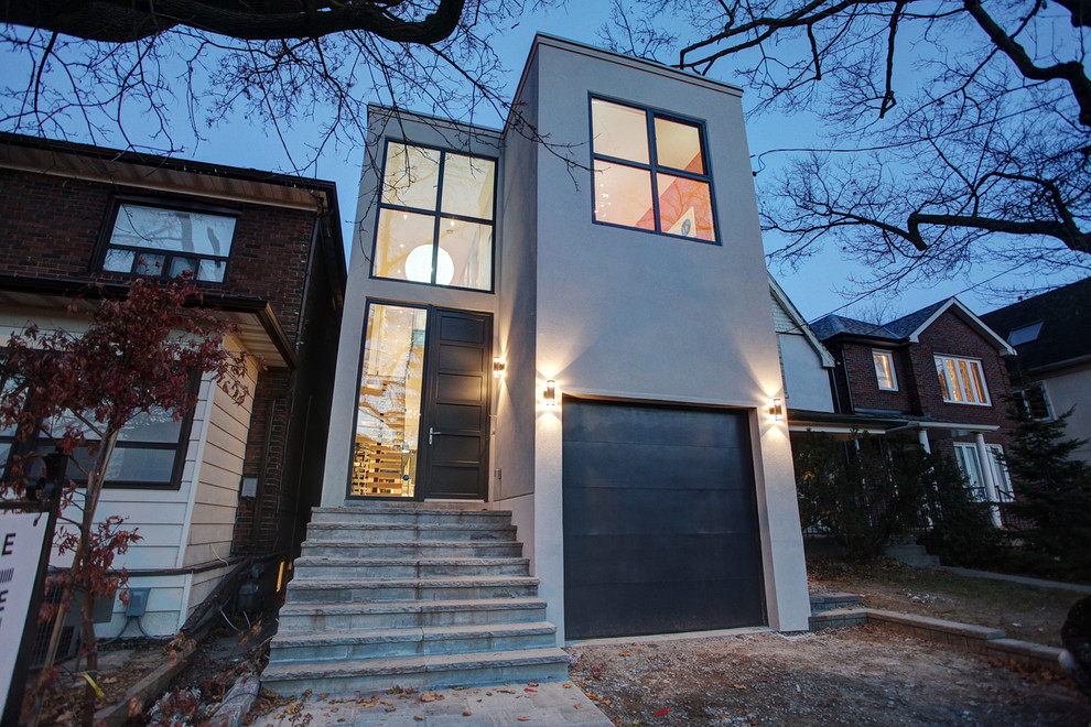 Inspiration for a mid-sized modern two-storey concrete grey house exterior in Toronto with a flat roof.