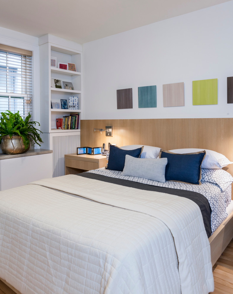 Photo of a large contemporary gender-neutral kids' room in New York with white walls and light hardwood floors.