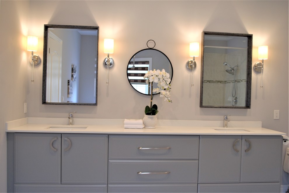 Large transitional master porcelain tile and beige floor freestanding bathtub photo in Toronto with flat-panel cabinets, gray cabinets, a one-piece toilet, gray walls, an undermount sink, quartzite countertops, a hinged shower door and white countertops