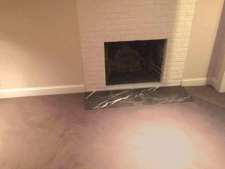 Inspiration for a mid-sized transitional underground carpeted and beige floor basement remodel with beige walls, a standard fireplace and a brick fireplace
