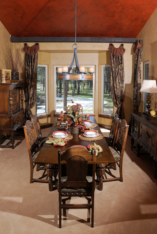 This is an example of a mid-sized country separate dining room in Denver with red walls, carpet, no fireplace and beige floor.