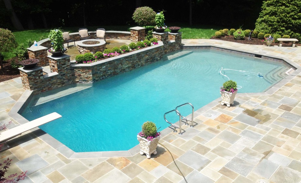 Large transitional backyard stone and custom-shaped lap pool photo in Detroit