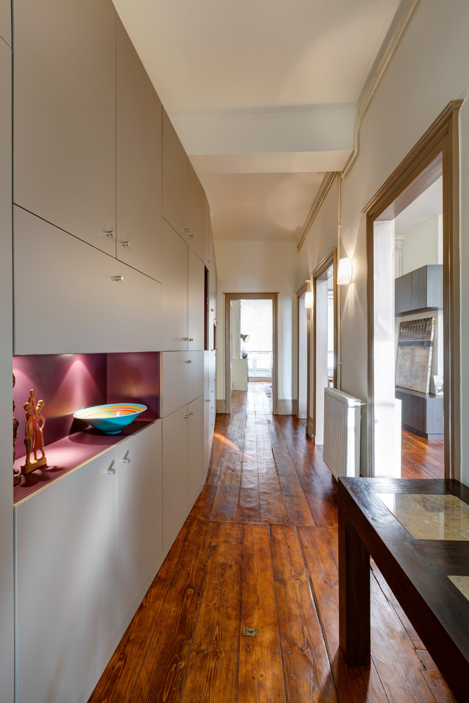 Photo of a mid-sized contemporary hallway in Bordeaux with beige walls and medium hardwood floors.