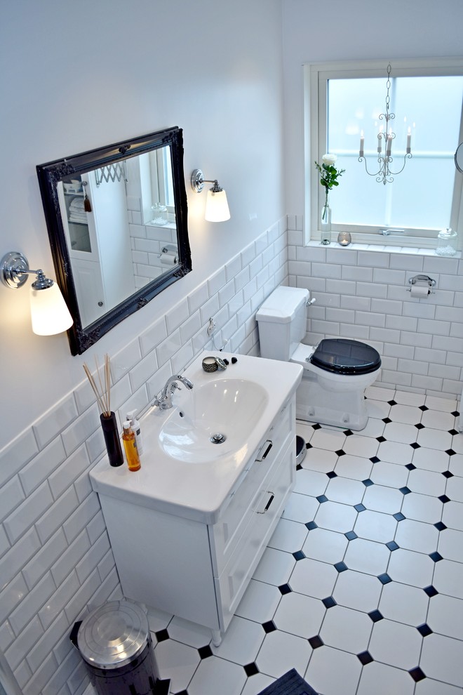 Mid-sized traditional 3/4 bathroom in Malmo with beaded inset cabinets, white cabinets, white tile and a trough sink.
