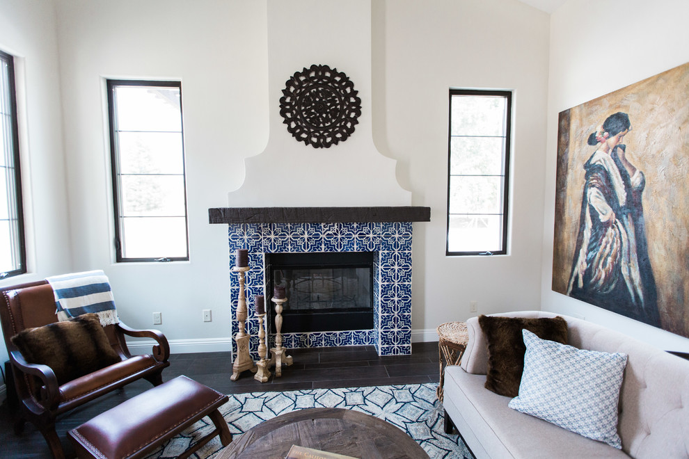 Inspiration for a mid-sized mediterranean formal open concept living room in Other with beige walls, dark hardwood floors, a standard fireplace, a tile fireplace surround, a freestanding tv and brown floor.
