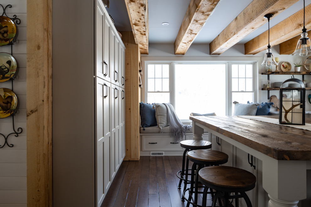 Example of a large country l-shaped dark wood floor, brown floor and exposed beam eat-in kitchen design in Portland Maine with a farmhouse sink, shaker cabinets, gray cabinets, marble countertops, white backsplash, shiplap backsplash, stainless steel appliances, an island and white countertops