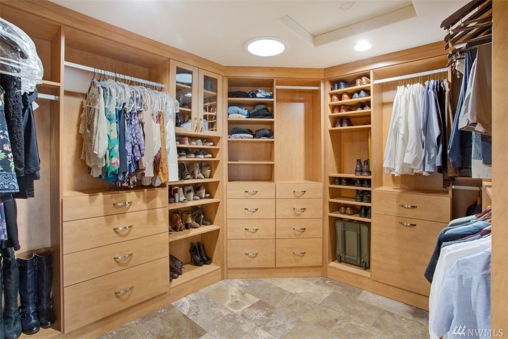 Photo of a large contemporary gender-neutral walk-in wardrobe in Other with flat-panel cabinets, medium wood cabinets and travertine floors.