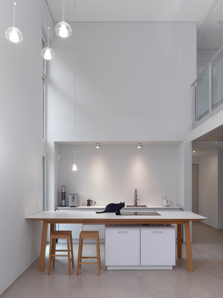 Photo of a modern kitchen in Other with a single-bowl sink, flat-panel cabinets, white cabinets, white splashback, concrete floors, a peninsula, grey floor and white benchtop.