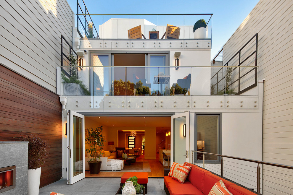Photo of a contemporary backyard patio in San Francisco with tile, no cover and with fireplace.
