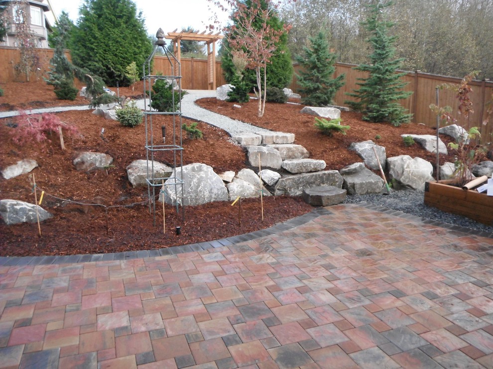 This is an example of a large transitional full sun backyard brick landscaping in Seattle.