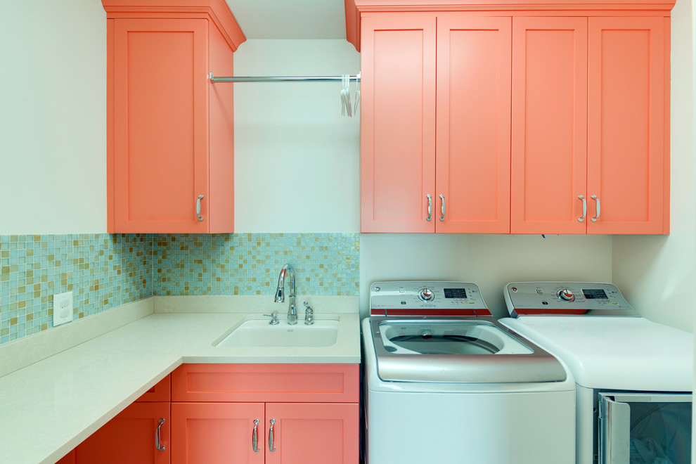 Mid-sized contemporary l-shaped dedicated laundry room in Charlotte with recessed-panel cabinets, orange cabinets, limestone benchtops, white walls, a side-by-side washer and dryer and an undermount sink.