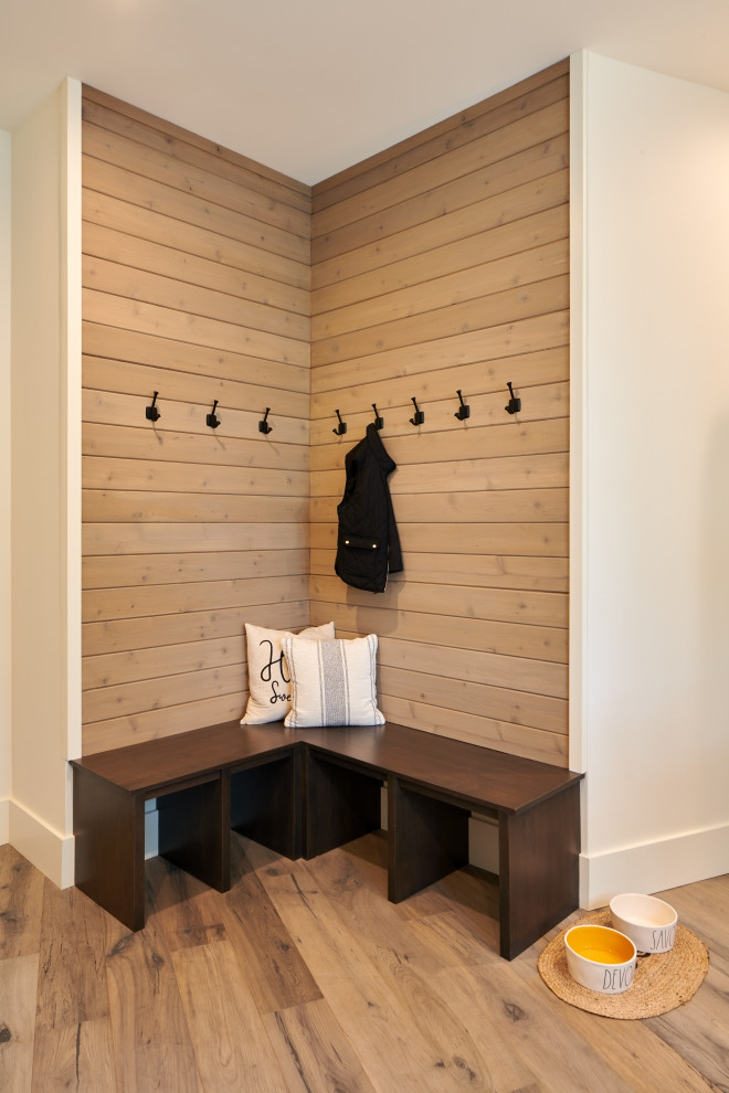 Photo of a large country u-shaped utility room in Seattle with an undermount sink, recessed-panel cabinets, brown cabinets, wood benchtops, black splashback, ceramic splashback, white walls, light hardwood floors, a side-by-side washer and dryer, brown floor, black benchtop and planked wall panelling.