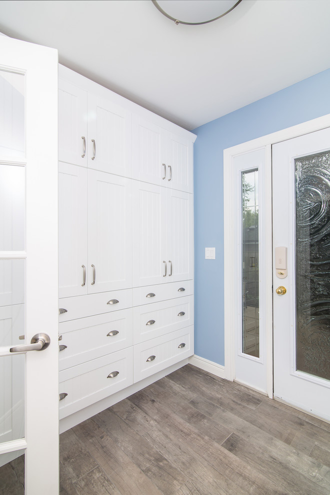 Mudroom - mid-sized transitional light wood floor mudroom idea with blue walls and a glass front door