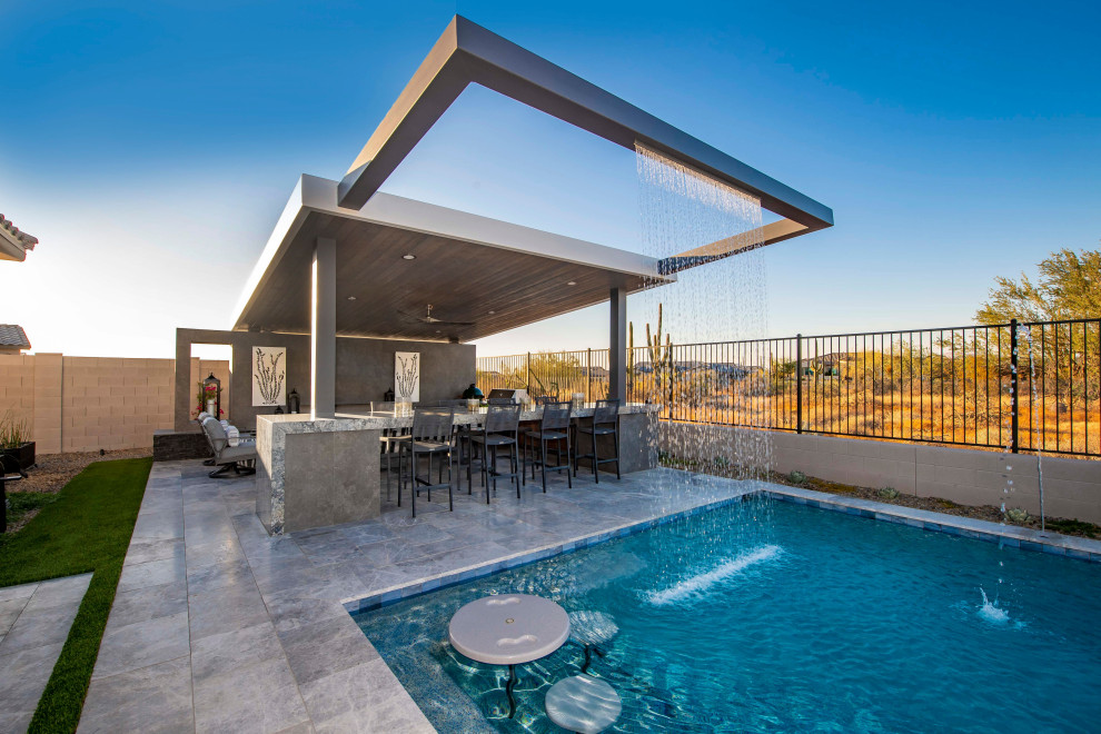 Photo of a contemporary backyard xeriscape in Phoenix with with waterfall and decking.