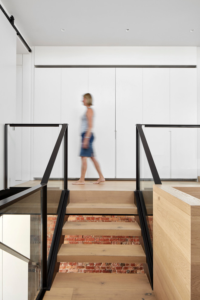 Inspiration for a small contemporary wood u-shaped staircase in Melbourne with open risers and glass railing.