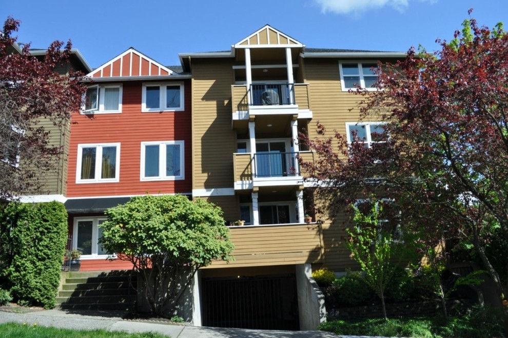 This is an example of a three-storey red exterior in Seattle with vinyl siding.