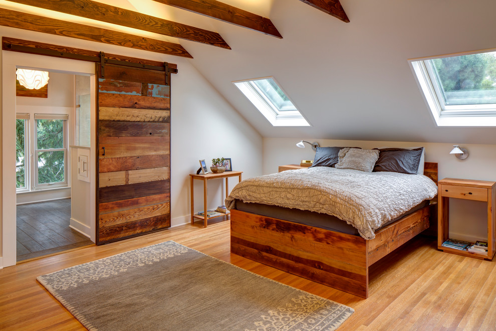 This is an example of a contemporary bedroom in Portland with white walls and light hardwood floors.