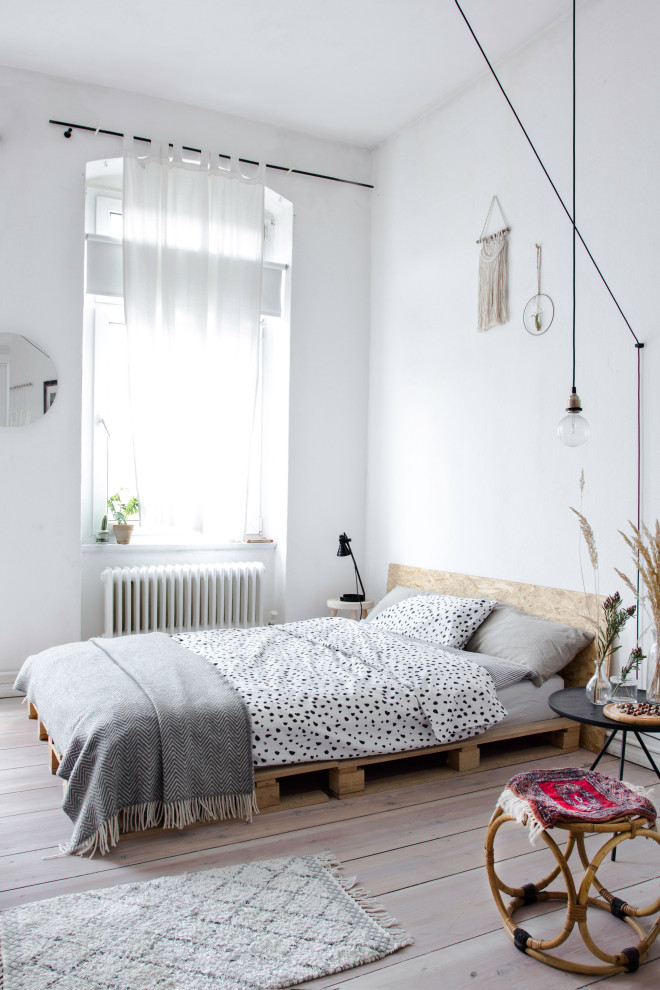 Mid-sized scandinavian master bedroom in Berlin with red walls, light hardwood floors and beige floor.