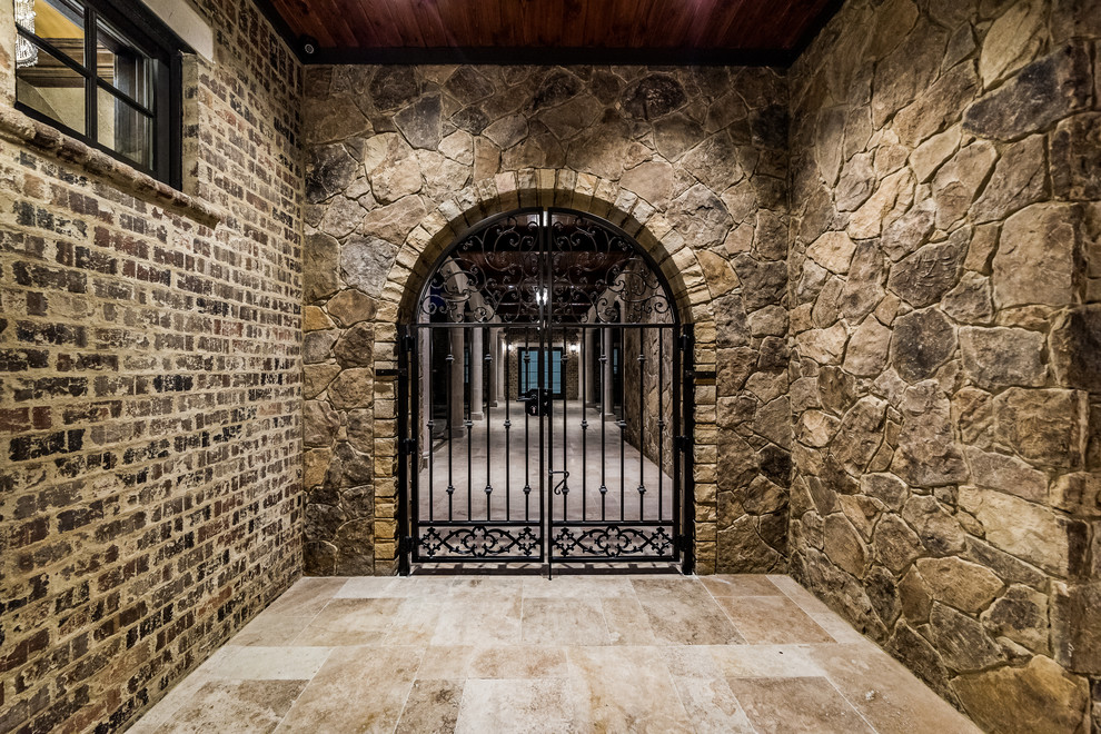 Mid-sized mountain style travertine floor and beige floor foyer photo with brown walls and a glass front door