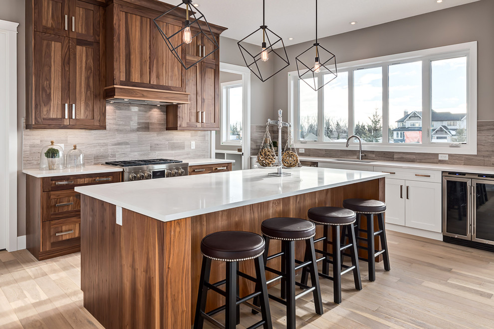 Example of a mid-sized transitional galley light wood floor eat-in kitchen design in Calgary with a drop-in sink, recessed-panel cabinets, medium tone wood cabinets, quartz countertops, gray backsplash, ceramic backsplash, stainless steel appliances and an island