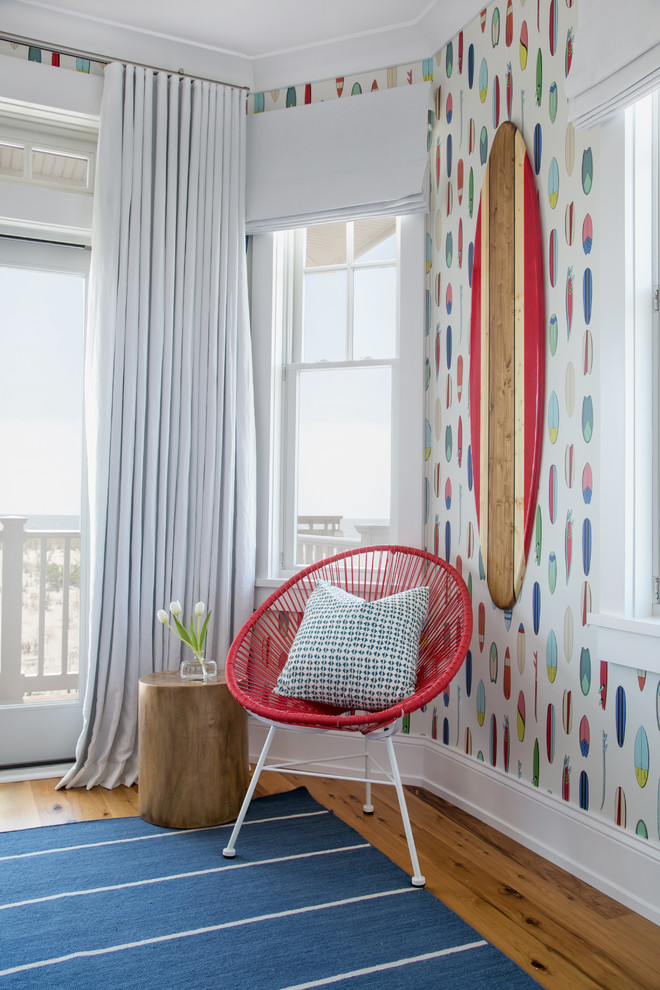 Inspiration for an expansive beach style gender-neutral kids' bedroom for kids 4-10 years old in New York with white walls and medium hardwood floors.