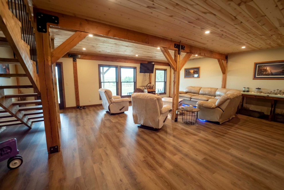 Inspiration for a mid-sized country walk-out basement with beige walls, medium hardwood floors, no fireplace, brown floor and wood.