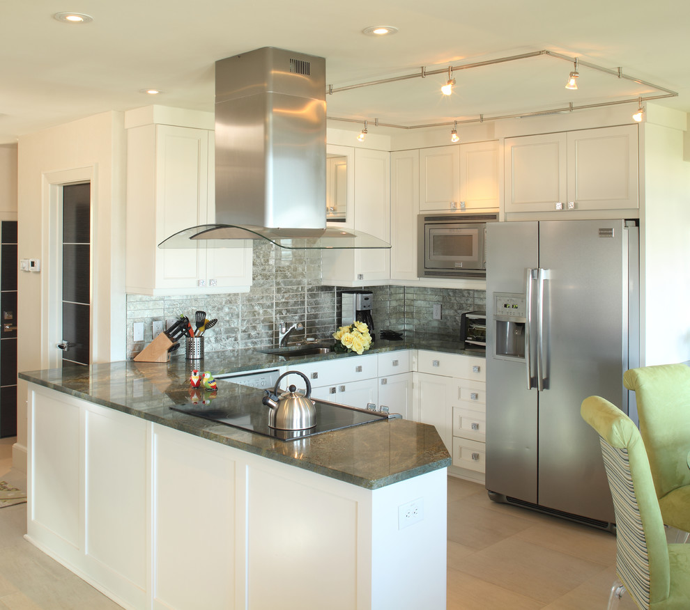 This is an example of a small beach style u-shaped eat-in kitchen in Charleston with a drop-in sink, raised-panel cabinets, white cabinets, wood benchtops, metallic splashback, glass tile splashback, stainless steel appliances, cement tiles, no island, beige floor and grey benchtop.