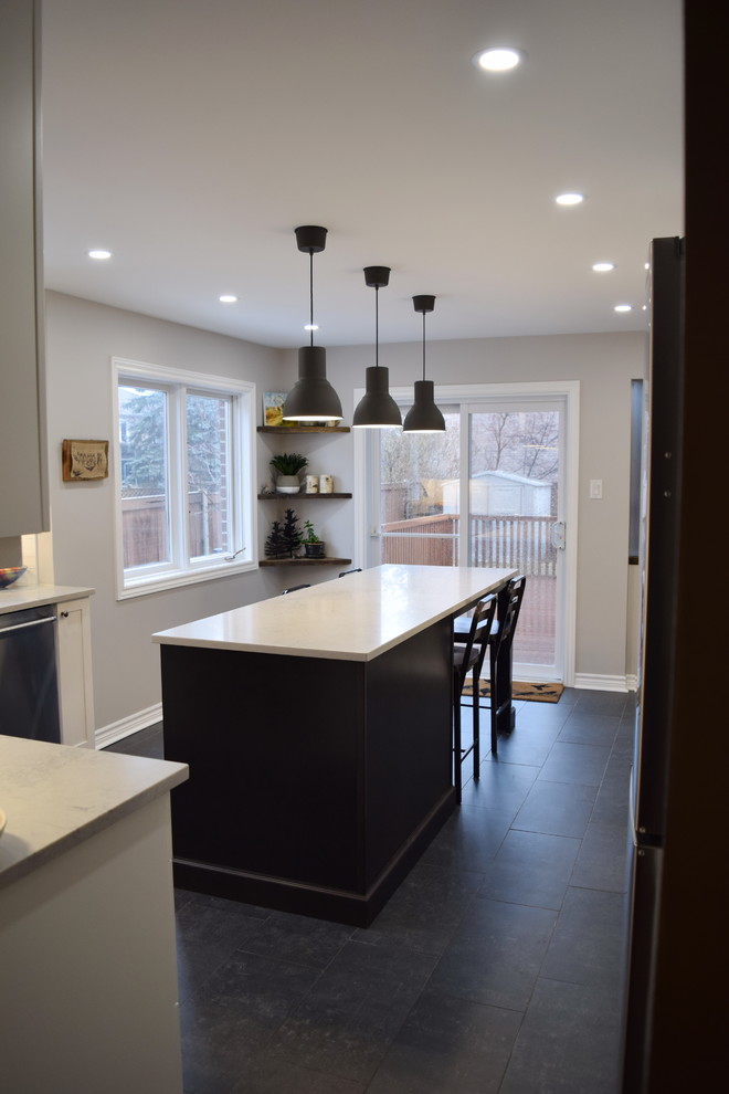 Mid-sized transitional l-shaped ceramic tile enclosed kitchen photo in Ottawa with an undermount sink, shaker cabinets, white cabinets, quartz countertops, white backsplash, subway tile backsplash, stainless steel appliances and an island