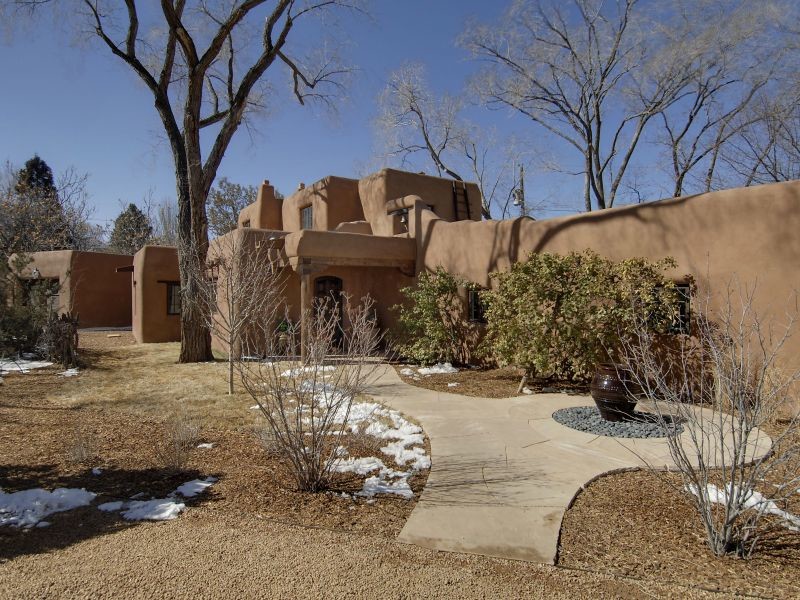 Inspiration for a mid-sized two-storey adobe brown exterior in Albuquerque with a flat roof.