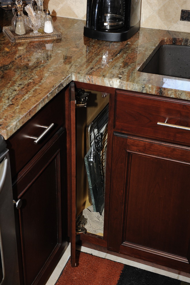 Mid-sized transitional u-shaped limestone floor enclosed kitchen photo in Baltimore with an undermount sink, beaded inset cabinets, dark wood cabinets, granite countertops, beige backsplash, stone tile backsplash, stainless steel appliances and a peninsula