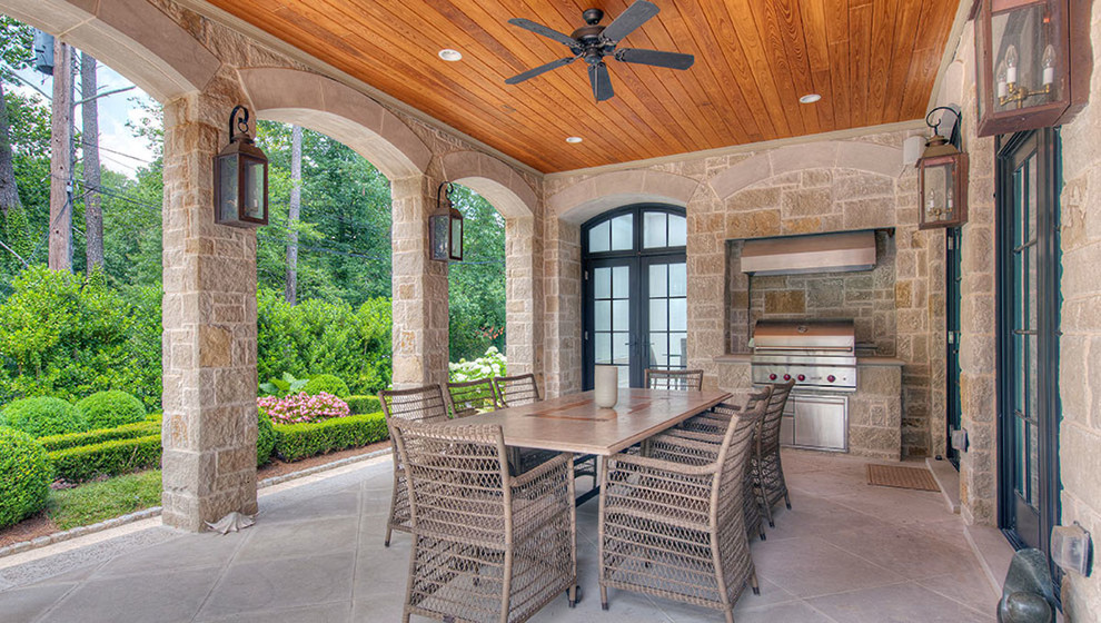 Large traditional backyard patio in Atlanta with an outdoor kitchen, tile and a roof extension.