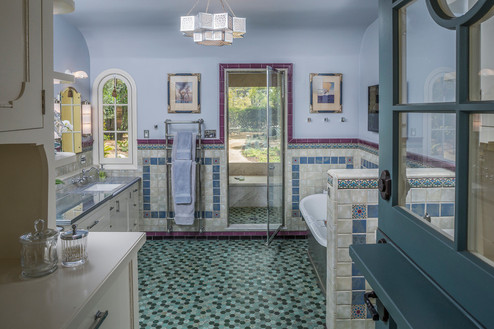 Beach style master bathroom in Los Angeles with recessed-panel cabinets, white cabinets, a freestanding tub, a one-piece toilet, blue tile, ceramic tile, blue walls, mosaic tile floors, an undermount sink and zinc benchtops.