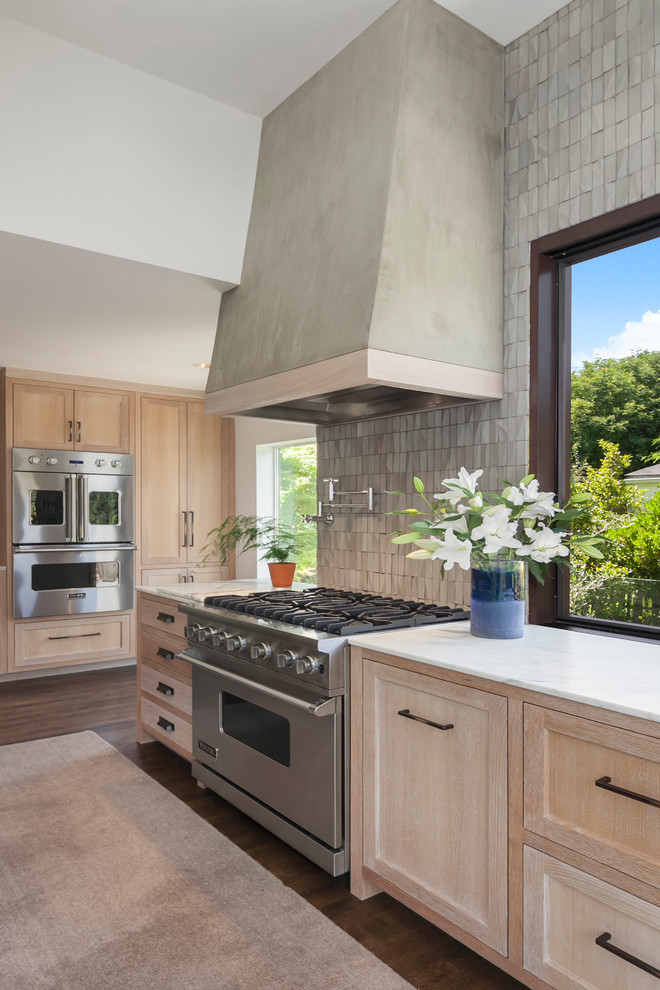 Large contemporary l-shaped open plan kitchen in Seattle with an undermount sink, recessed-panel cabinets, light wood cabinets, marble benchtops, grey splashback, cement tile splashback, stainless steel appliances, dark hardwood floors, with island and brown floor.