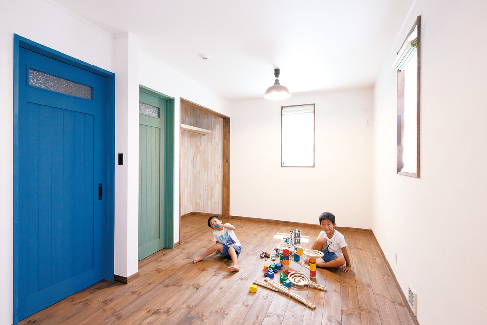 This is an example of a country kids' room in Other with white walls and dark hardwood floors.