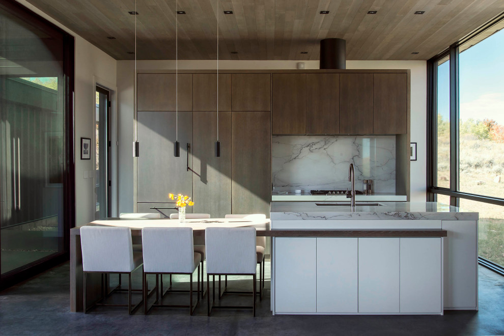 Inspiration for a mid-sized contemporary galley kitchen in Salt Lake City with flat-panel cabinets, quartz benchtops, concrete floors, with island, grey floor, an undermount sink, medium wood cabinets, grey splashback, panelled appliances, grey benchtop and wood.