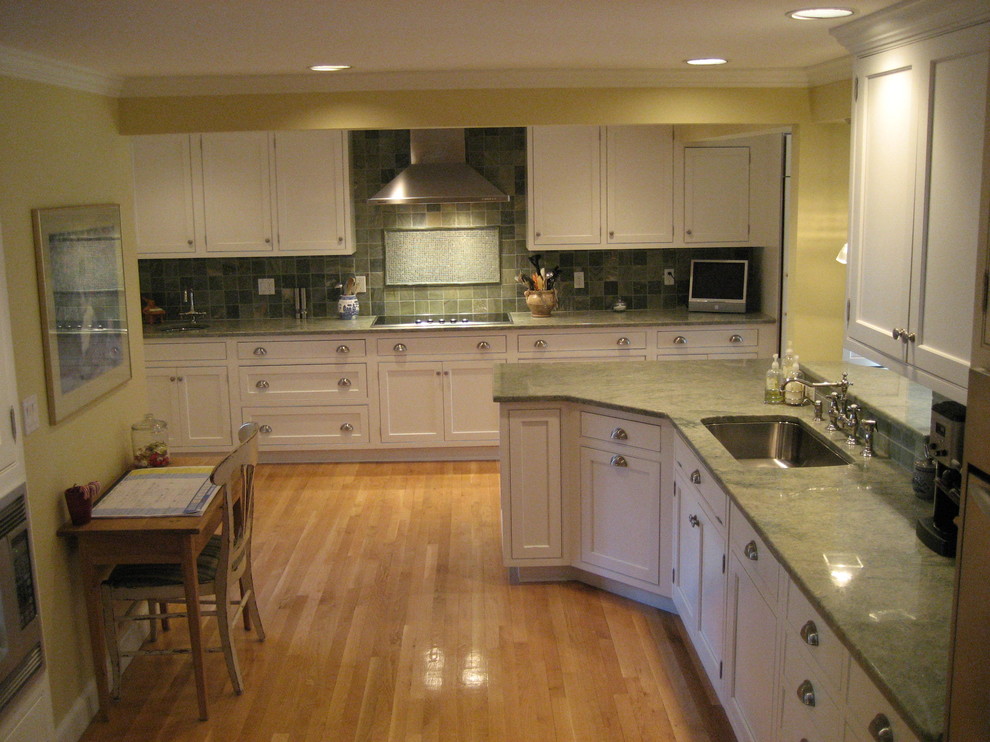 Design ideas for a traditional l-shaped eat-in kitchen in Boston with an undermount sink, shaker cabinets, white cabinets, granite benchtops, green splashback, mosaic tile splashback, stainless steel appliances, light hardwood floors and green benchtop.