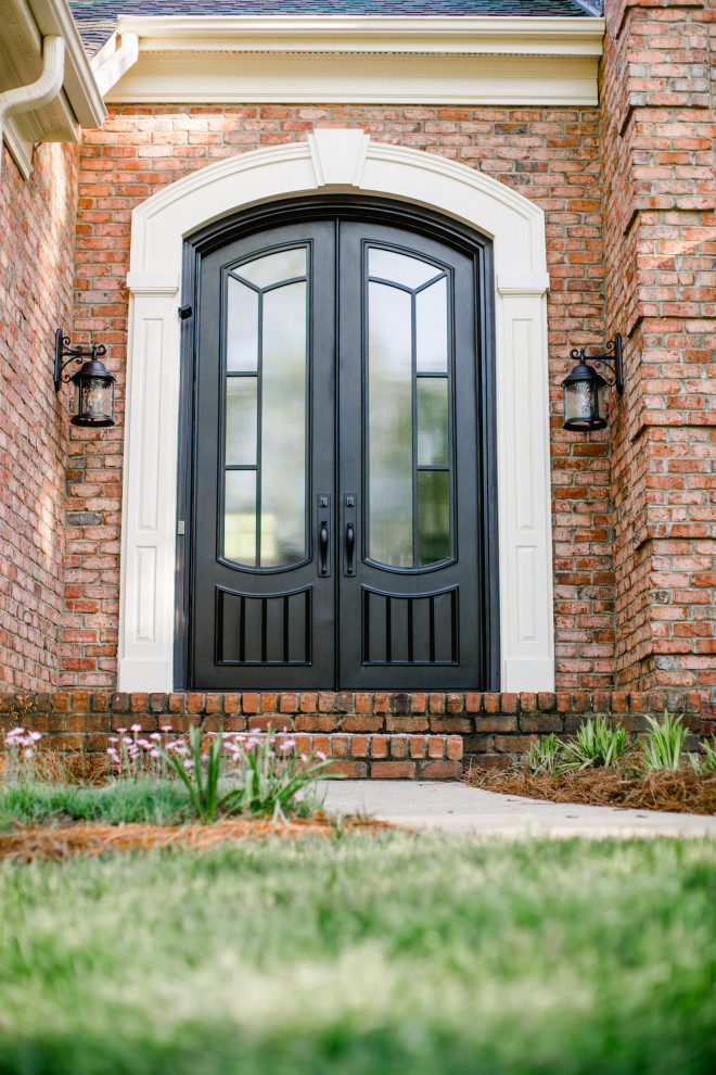 This is an example of a large traditional front door in Charlotte with brown walls, a double front door and a black front door.