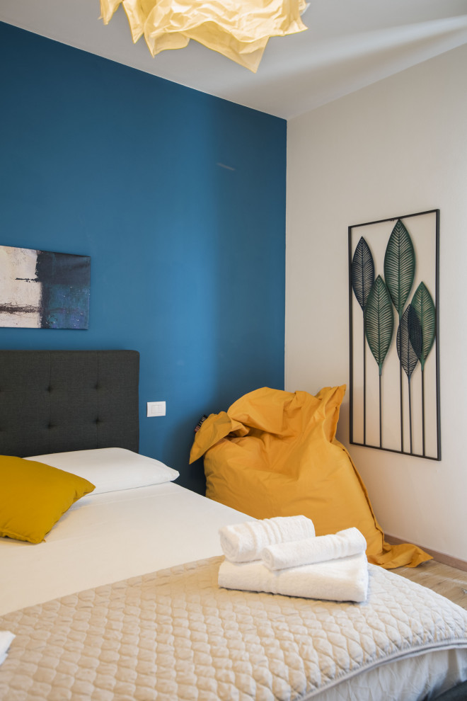 Aménagement d'une chambre d'amis moderne de taille moyenne avec un mur bleu, parquet peint et un sol marron.