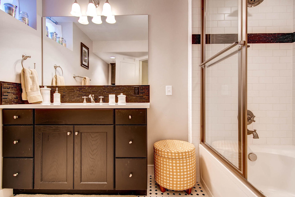 Photo of a modern 3/4 bathroom in Denver with flat-panel cabinets, dark wood cabinets, a drop-in tub, a shower/bathtub combo, a one-piece toilet, black and white tile, ceramic tile, beige walls, ceramic floors, a drop-in sink and laminate benchtops.