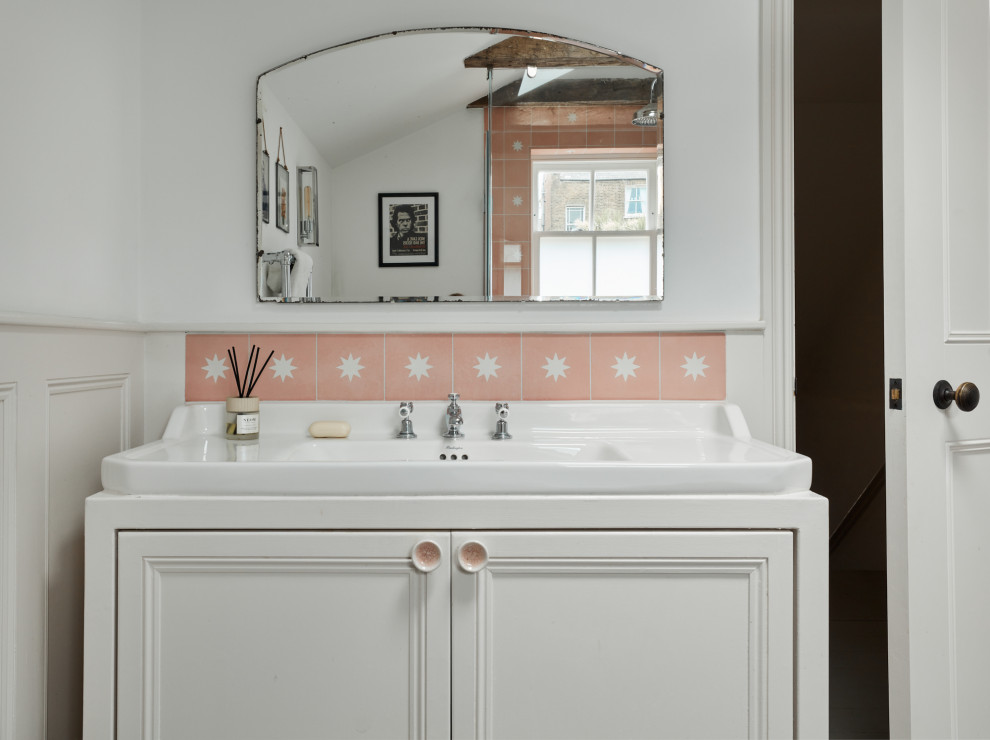 Стильный дизайн: маленькая детская ванная комната в стиле фьюжн с фасадами с утопленной филенкой, бежевыми фасадами, отдельно стоящей ванной, открытым душем, инсталляцией, розовой плиткой, цементной плиткой, белыми стенами, деревянным полом, врезной раковиной, серым полом, душем с распашными дверями, белой столешницей, нишей, тумбой под одну раковину, напольной тумбой, балками на потолке и панелями на части стены для на участке и в саду - последний тренд