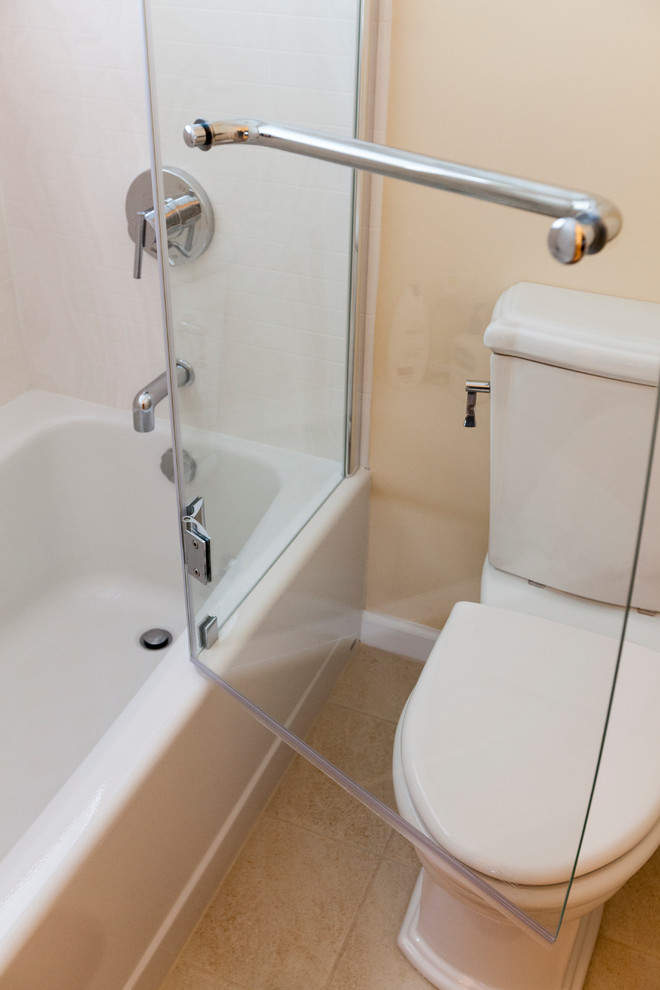 This is an example of a mid-sized eclectic bathroom in Bridgeport with a vessel sink, flat-panel cabinets, light wood cabinets, engineered quartz benchtops, an alcove tub, a shower/bathtub combo, a two-piece toilet, beige tile, porcelain tile, orange walls and porcelain floors.