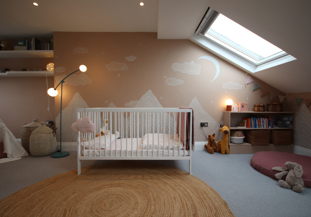 Mid-sized modern nursery in Cambridgeshire with pink walls, dark hardwood floors, grey floor and wallpaper for girls.