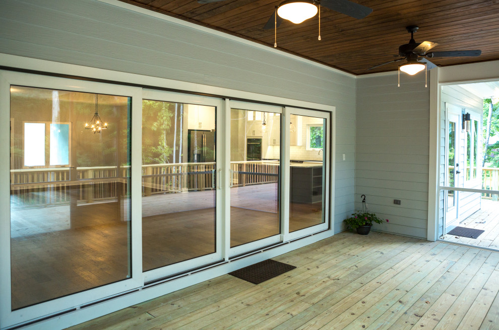 Deck - mid-sized traditional backyard ground level wood railing deck idea with a roof extension