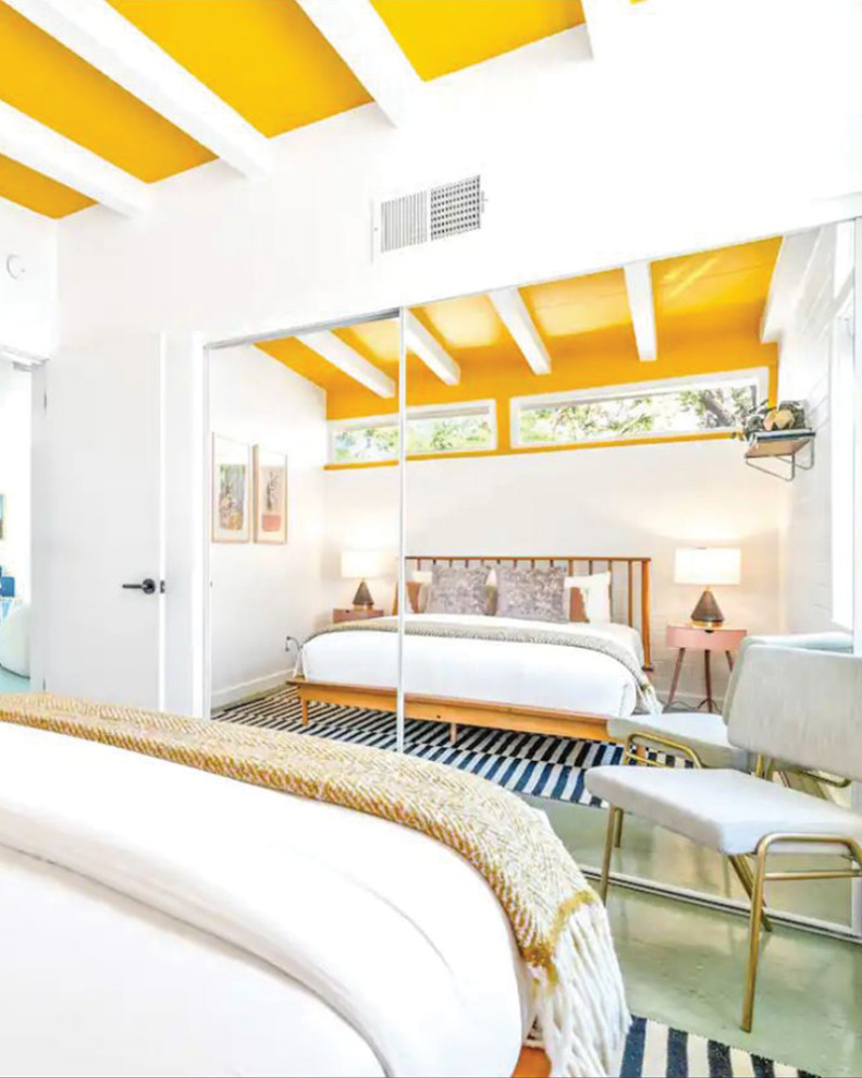 Esempio di una camera degli ospiti moderna con pareti bianche, pavimento in laminato, pavimento verde, travi a vista e pareti in mattoni