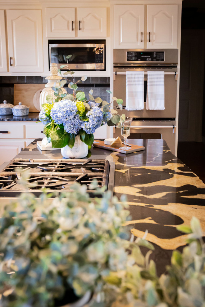 Eat-in kitchen - large transitional l-shaped medium tone wood floor and brown floor eat-in kitchen idea in Boston with a double-bowl sink, recessed-panel cabinets, white cabinets, granite countertops, beige backsplash, glass tile backsplash, stainless steel appliances, an island and white countertops