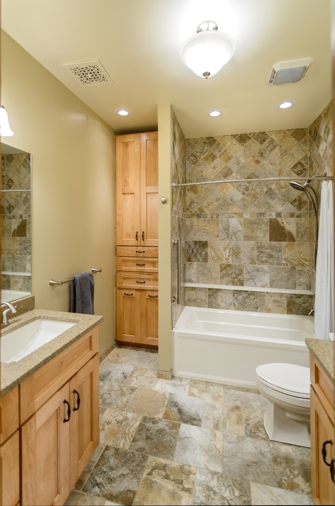 Inspiration for a country 3/4 bathroom in Charleston with an undermount sink, recessed-panel cabinets, light wood cabinets, granite benchtops, an alcove tub, a double shower, a two-piece toilet, multi-coloured tile, stone tile, brown walls and porcelain floors.