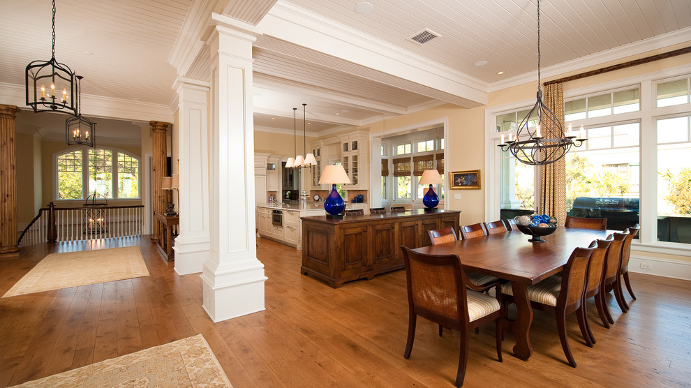 This is an example of a large traditional open plan dining in Charleston with yellow walls, medium hardwood floors and a standard fireplace.