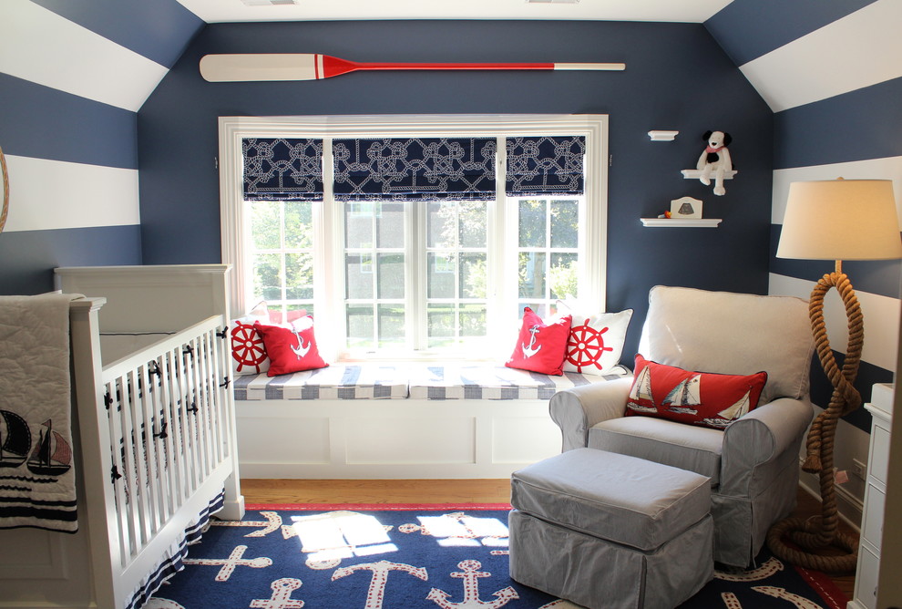 Small beach style nursery in Chicago with blue walls and medium hardwood floors for boys.